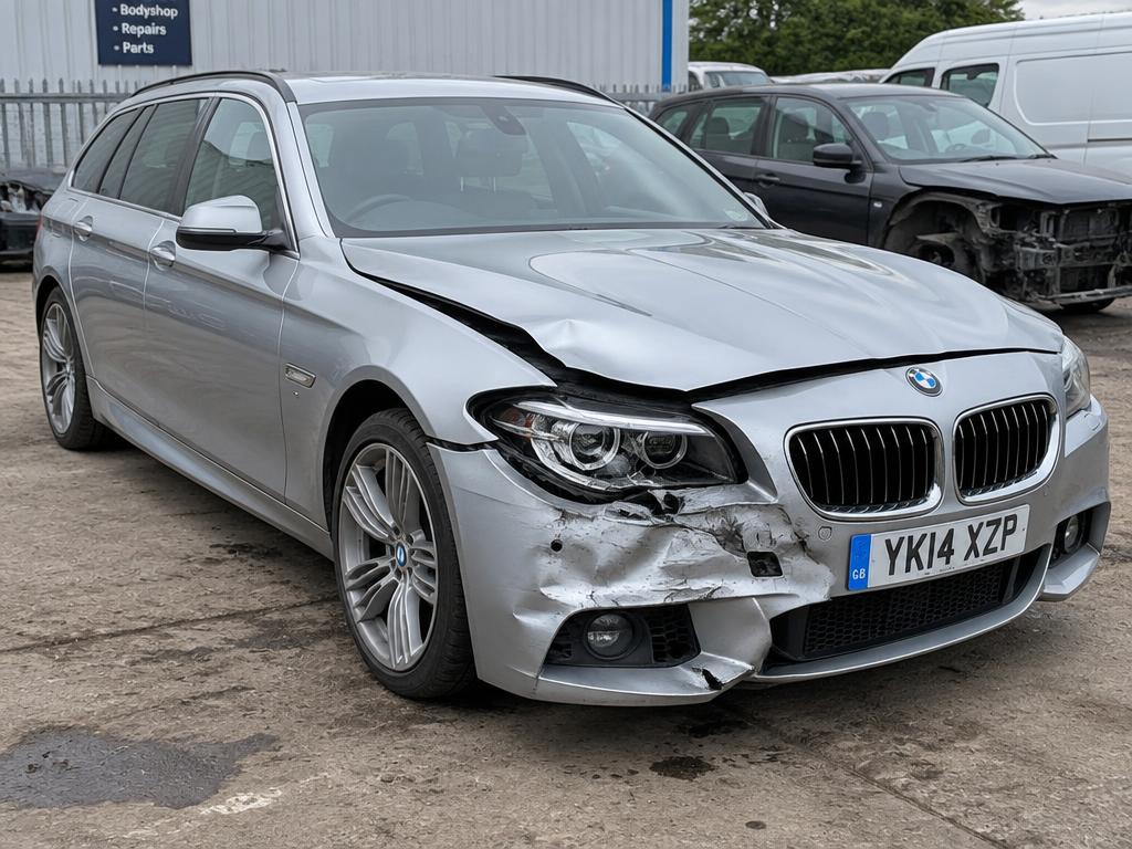 Zilveren BMW 5-Serie Touring met aanrijdingsschade aan de voorzijde